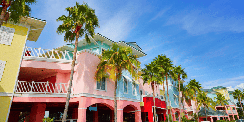 Row of buildings with colorful facades and palm trees in Fort Myers, FL